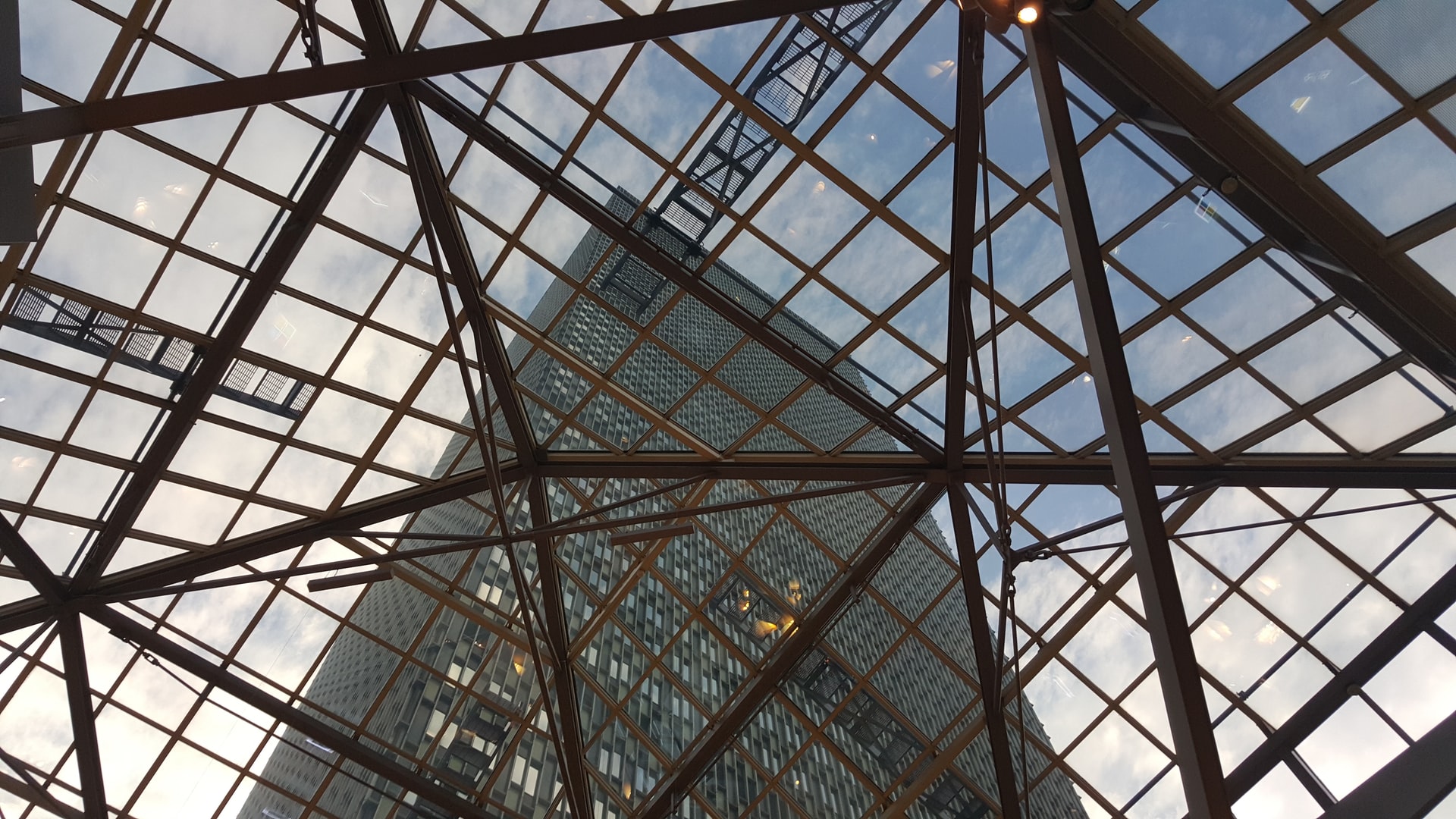 Transparent building roof structure with building and sky background